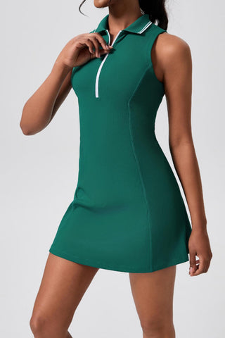 Woman wearing a green dress with a white collar on a plain background